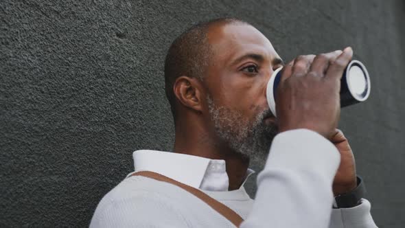 African American man drinking a coffee and using his phone