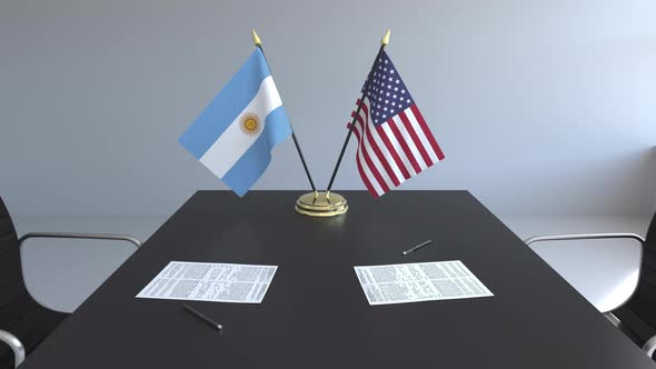 Flags of Argentina and the United States on the Table