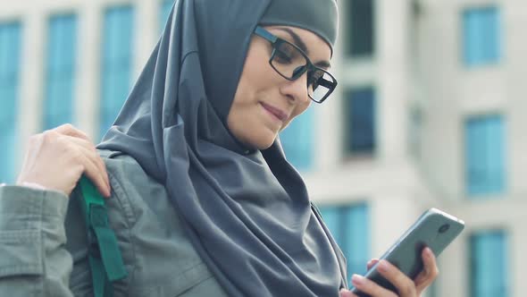 Happy Arab Girl Using Smartphone, Chatting With Friends After Classes in College