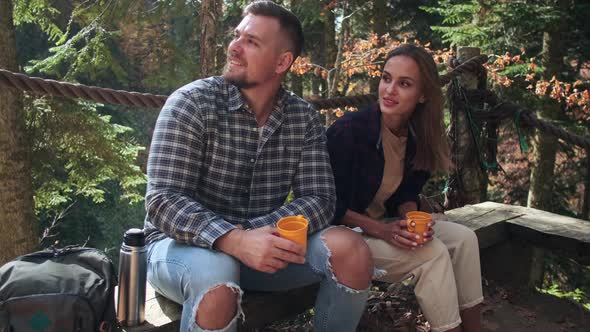 Man and Woman are Resting on Observation Deck in Forest