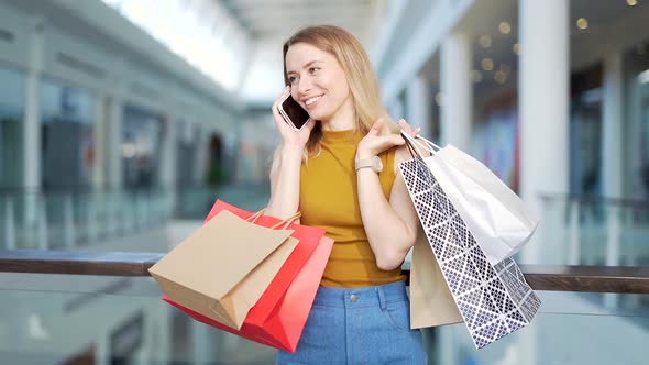 young happy after shopping woman talking on cell in mall.