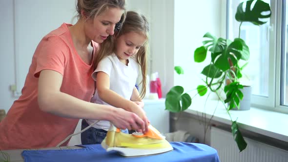 Woman Help Young Daughter Iron Clothes on Board Spbd