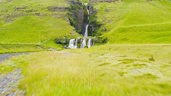 FPV Drone Flying Under Bridge To Reveal Beautiful Cascade Gluggafoss In Iceland. 4K Drone.