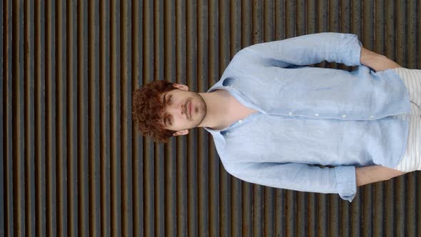 Vertical Video of a Young Italian Man in Summer Clothes Looking at the Camera