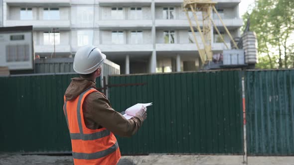 A High-Level Builder at a Construction Site Monitors Work