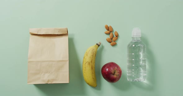 Animation of paper lunch bag an fruits on blue background