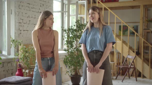 Two Beautiful Young Girls are Standing in the Studio with Lgbt Posters in Their Hands and Looking at