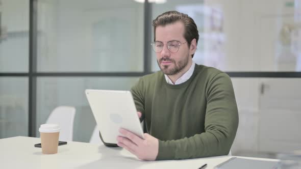 Young Businessman Using Tablet While Sitting in Office