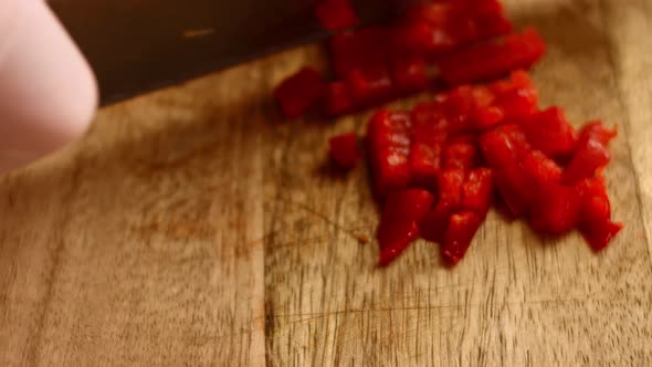 Hands of a Woman Peeling Frozen Red Bell Pepper on the Wooden Cutting Board