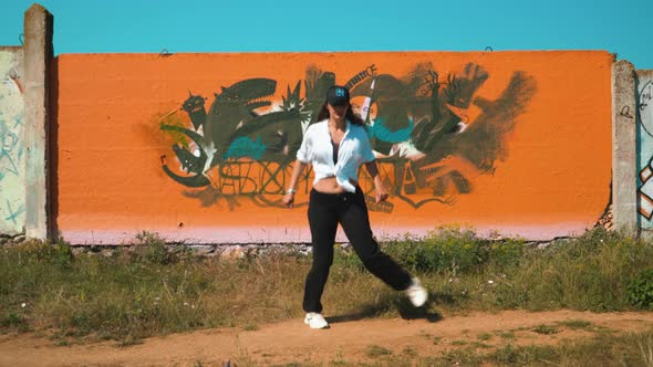 Girl Dancing Shuffle at the Orange Wall in the Charleston Style