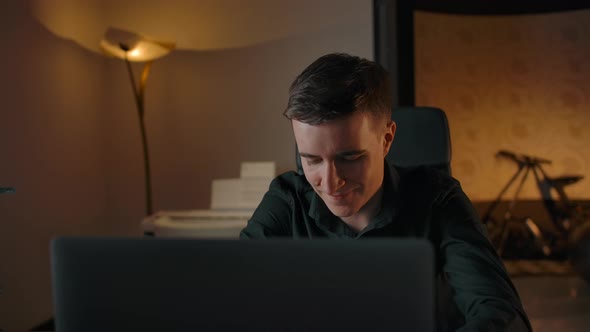 Smiling Entrepreneur Working on Laptop at Cozy Home Evening Interior