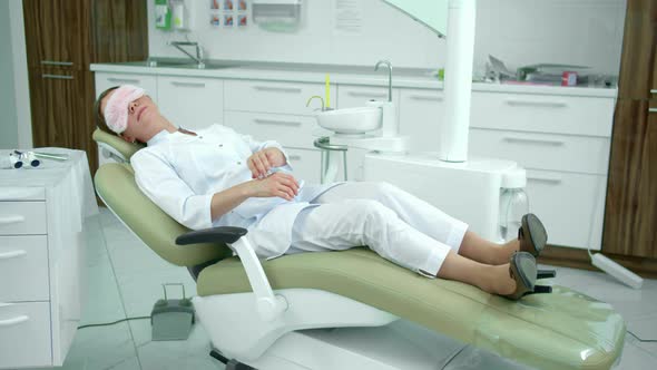 Tired Doctor Sleeps on a Dental Chair