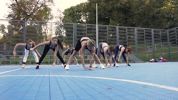 Athletic Women Doing Fitness Lunge Exercises on the Sportground on Sunny Day in the Park