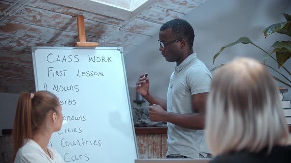 English Lesson in the Class with an African American Teacher - Two Women Sitting By the Table