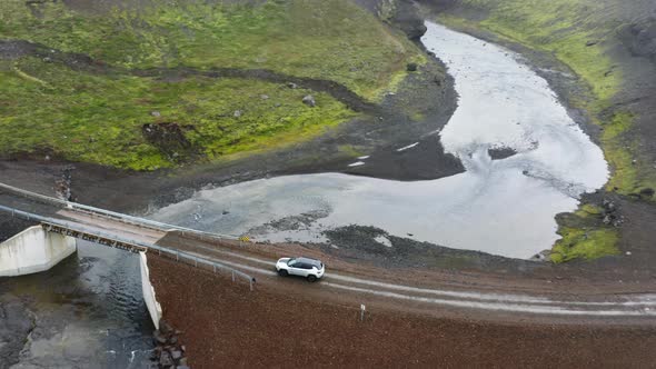 Aerial of Car Driving on Little Bridge Across the River in Highlands of Iceland
