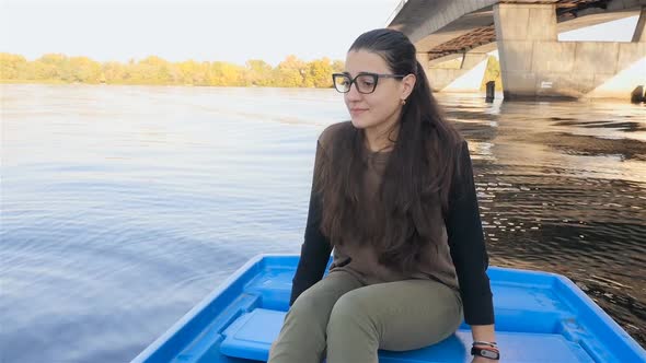 The Girl Sits in a Boat Rocking on the Waves