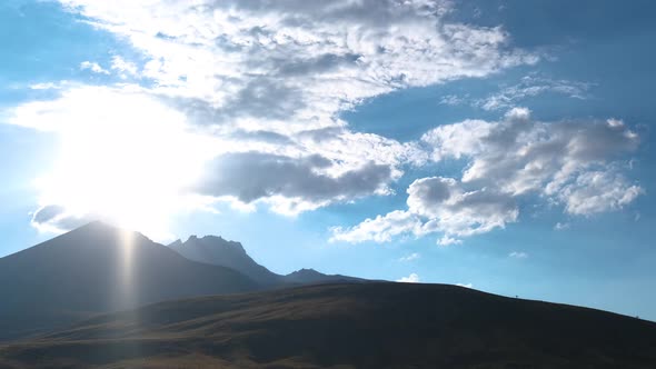 Time Lapse of Sun Movement in Crystal Clear Sky with Clouds Over Mountain Top