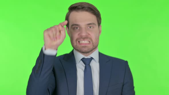 Angry Young Businessman Arguing on Green Background