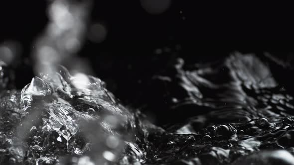 Boiling water on black background. Slow Motion.