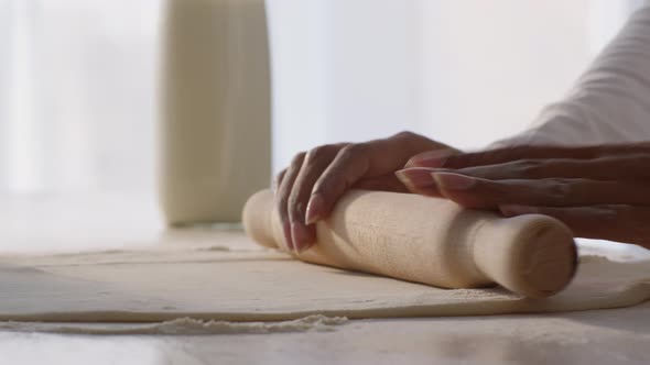 Professional Woman Baker Rolling Out Dough with Wooden Pin and Touching It Preparing Pastry on