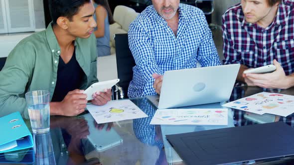 Business executives discussing over laptop