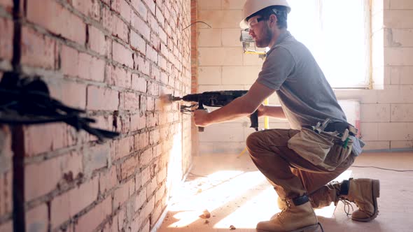 A construction worker works with a puncher close up.