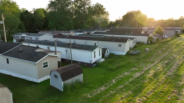 Aerial rising shot of beautiful sunset over mobile home park. Golden hour light in rural America. Lo