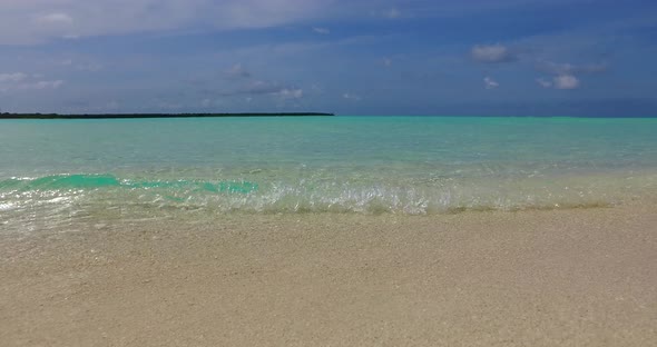 Tropical flying travel shot of a white sandy paradise beach and blue sea background 