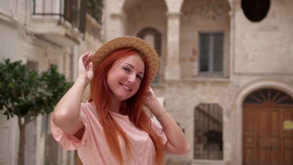 Portrait of Young Happy Redhaired Woman on Street of Old European City