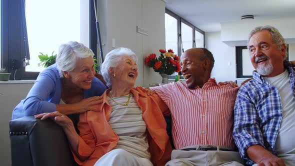 Happy senior friends having fun while relaxing on sofa 4k