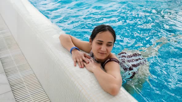 Young Woman Relaxing in the Pool is Enjoying Closeup Shot