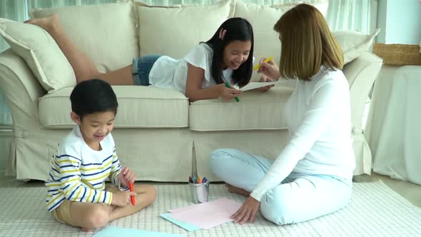 Asian Family Drawing Together In Living Room