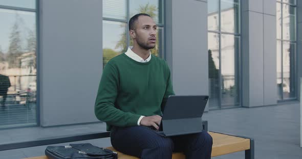 Multiracial Businessman Sitting on Bench Before Meeting With Partners