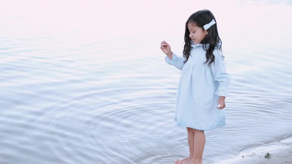 Lovely Girl Standing Near the Water on the Beach