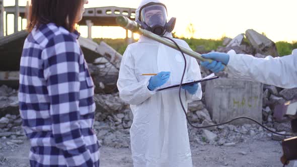 Portrait Scientists in Protective Suits and Masks and Dosimeter Measure Personal Ionizing Radiation