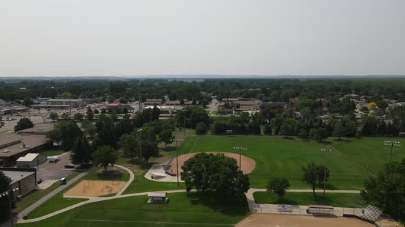 School and sports fields in Bismarck, North Dakota, with hazy sky and tree lined streets.