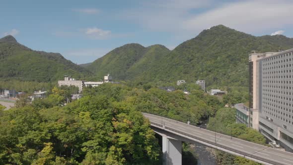 Short aerial pan shot revealing beautiful mountainous scenery in Jozankei famous hot spring onsen to