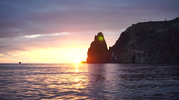 Colorful Warm Sunset Over the Sea and Rocky Shore