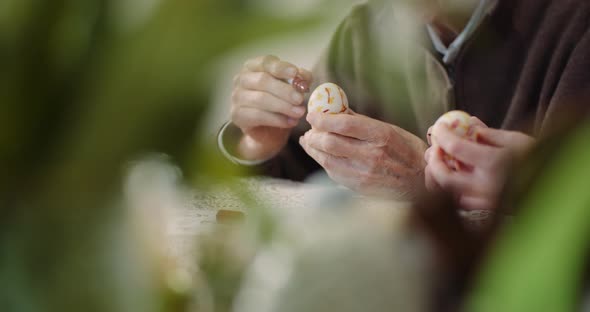 Senior Man Painting Easter Egg