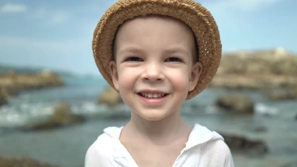 Portrait Cute Boy in a Straw Hat on the Beach