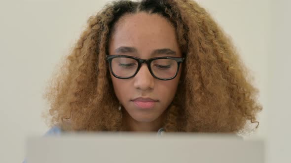 Portrait of African Woman Looking at Camera While Using Laptop