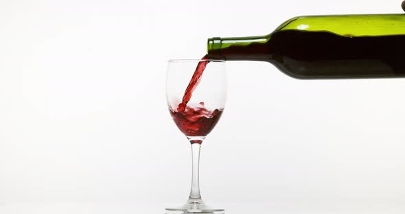 900126 Red Wine being poured into Glass, against White Background, Slow motion 4K