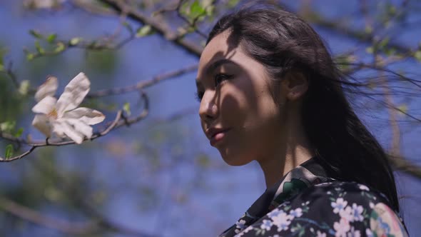 Side View Portrait of Young Confident Asian Woman Looking Away Raising Fan