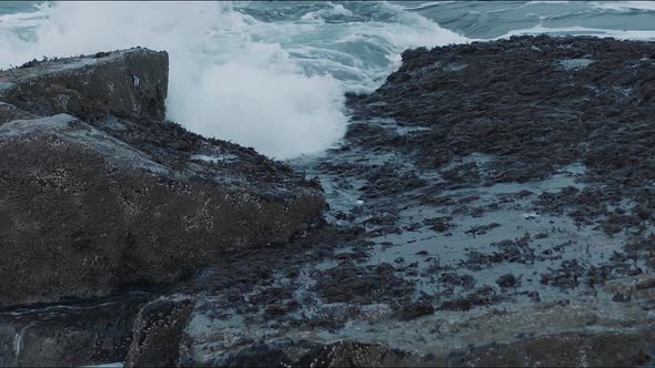 Sea Waves Roll on a Rocky Shore and Break on the Rocks Splashing Drops of Water