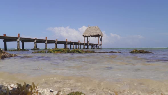 Calm Ocean Tide Coming Into Shore with Dock and Canopy in Background