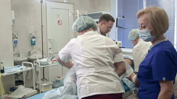 Team of Doctors and Nurses Preparing Patient for Gastroscopy