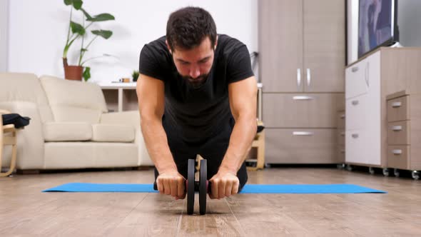 Sport at Home - Fit Man Doing Exercises with an Ab Whell