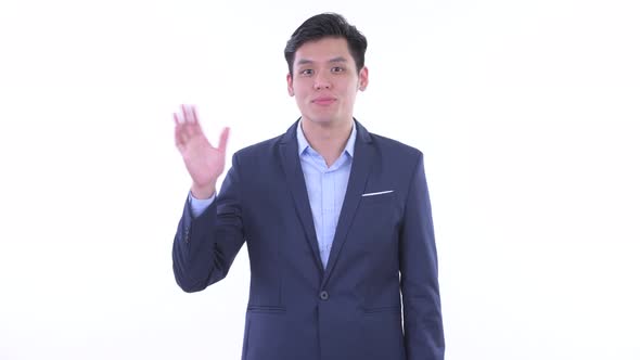 Happy Young Asian Businessman Waving Hand