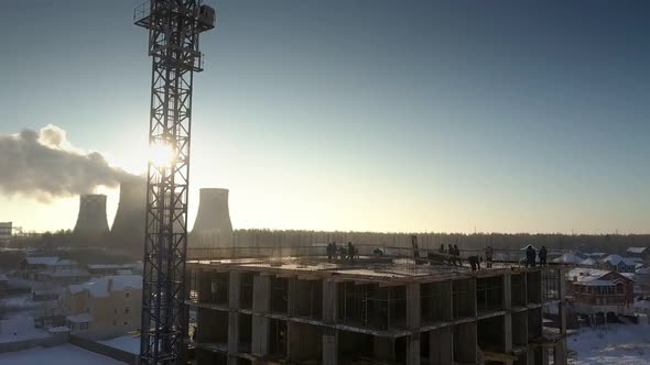 Aerial View Crane Stands Against Sun Near People Silhouettes