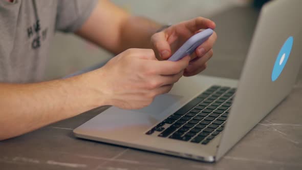 Young Man Typing on Laptop Keyboard at Home